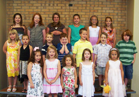 Image of the children's choir standing on risers singing