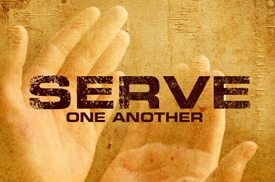 A pair of hands open and appearing to hold the text: "Serve One Another"