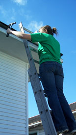 A female student working on the roof of a house